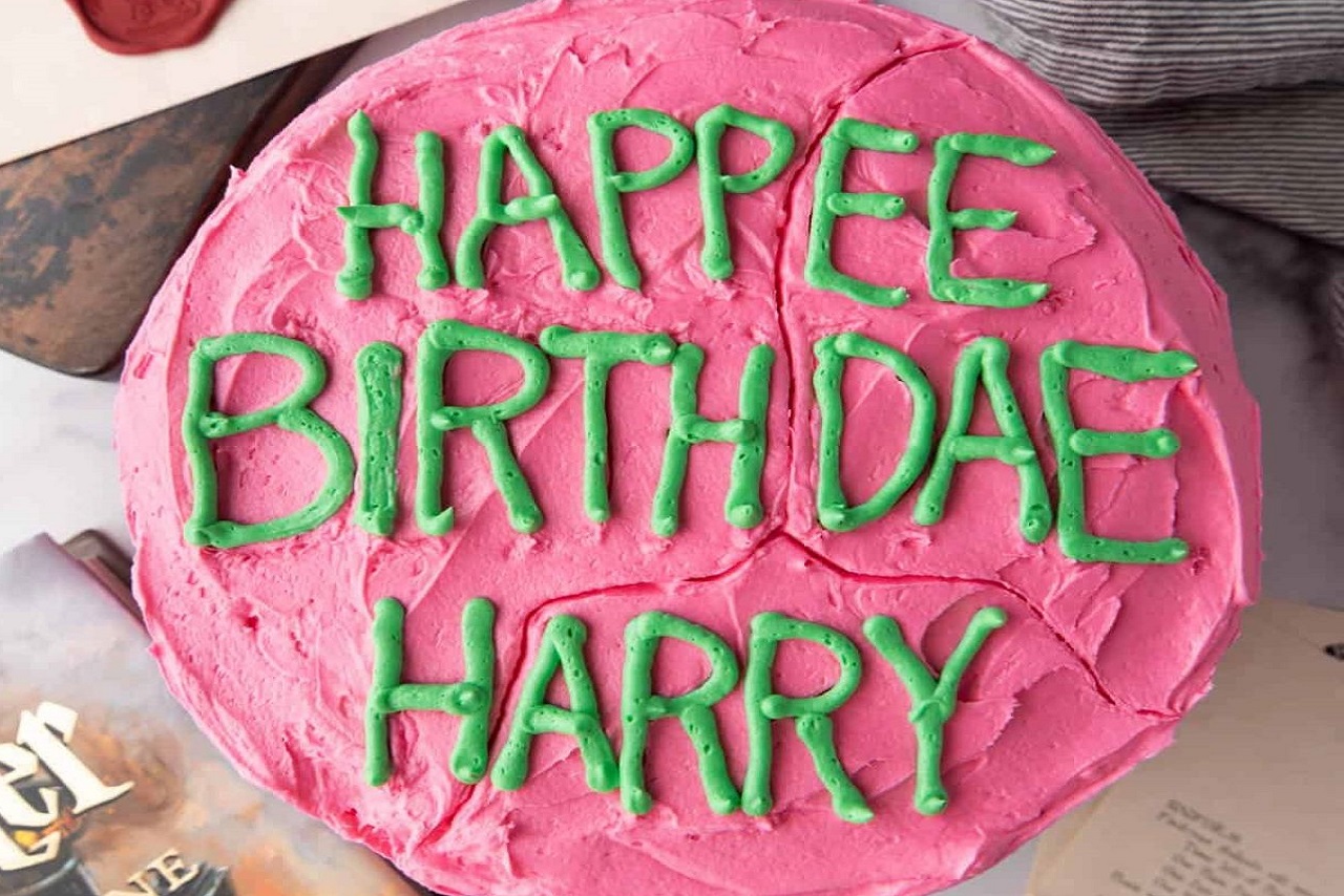 pink cake with green "Happee Birthdae Harry" icing